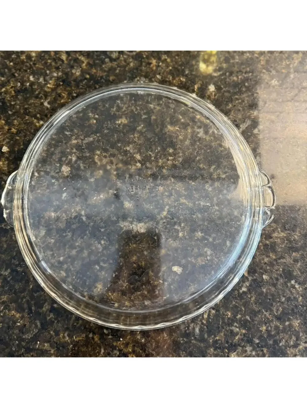 Vintage Pyrex pie plate with fluted edges and handles.